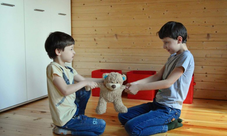 Sibling fighting constantly resolved using Mom Court conflict resolution method with parent mediating between two children at kitchen table