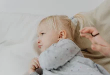 Toddler behavior guide showing a parent calmly helping a toddler during a tantrum
