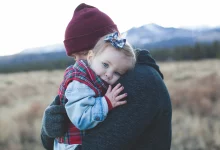 Toddler hitting and biting behavior as a parent calmly comforts an upset toddler during a tantrum