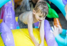 Toddler playing with inexpensive water play for toddler in backyard