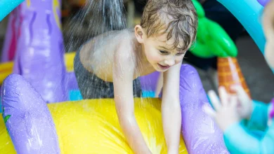 Toddler playing with inexpensive water play for toddler in backyard