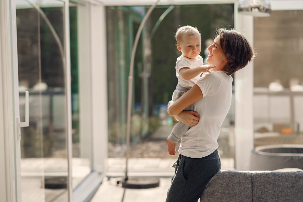 Mother comforts a toddler while Dad stays nearby during a parent preference phase