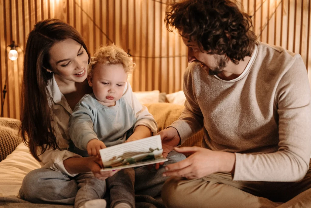 Parents calmly help their toddler transition from Mom to Dad during a daily routine