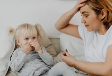 Toddler laughing while mother calmly sets a boundary during a parenting moment