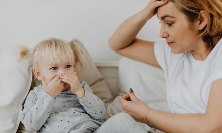 Toddler laughing while mother calmly sets a boundary during a parenting moment